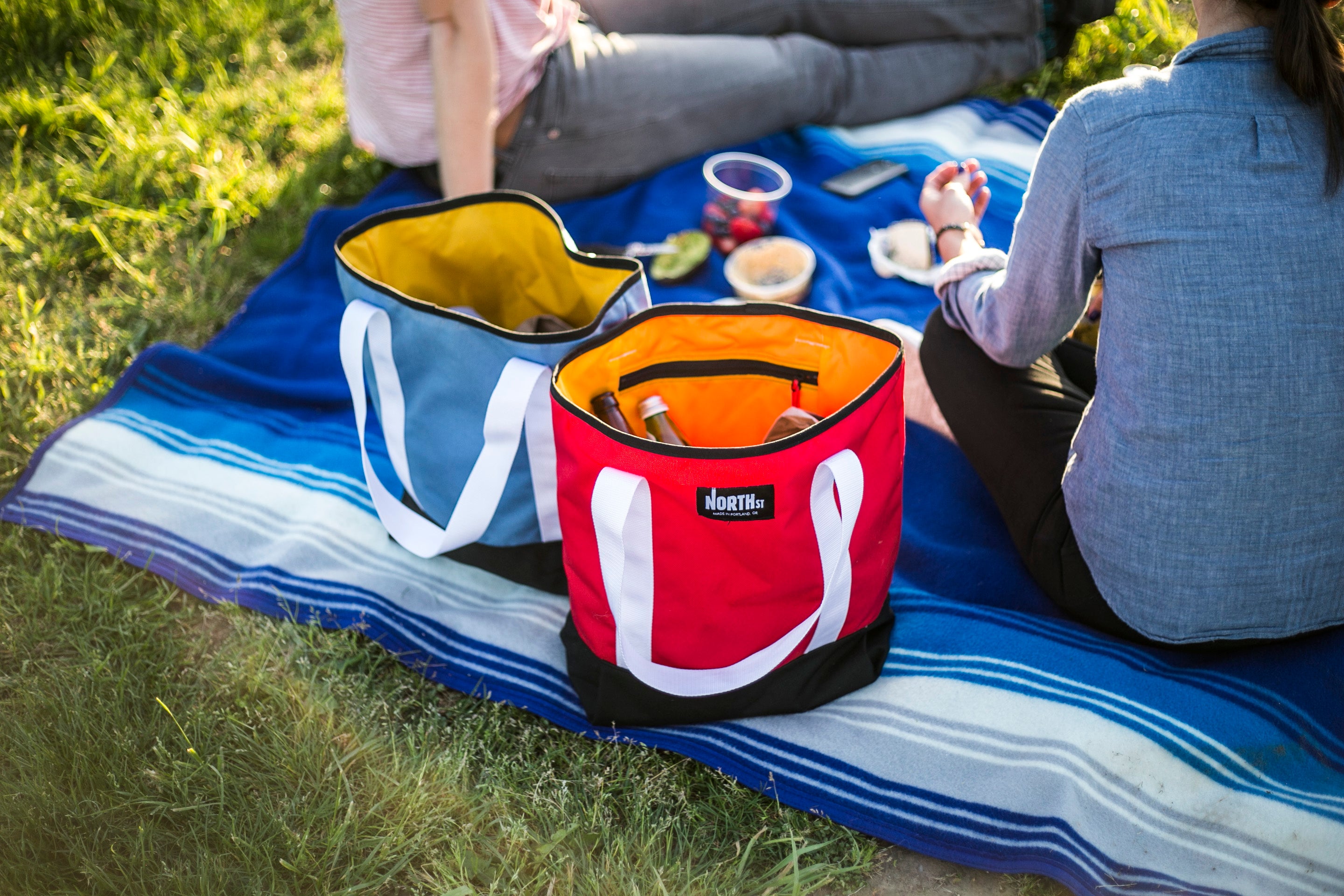 Couple on a picnic in a park with snacks and tote bags. - North St Bags all-groups