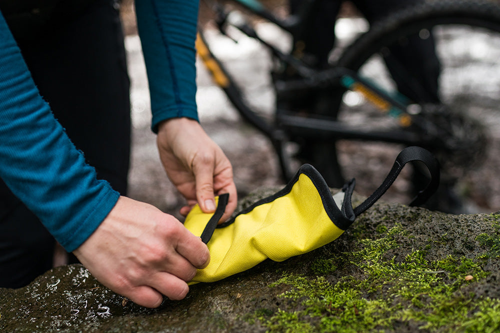Hands rolling up a tool roll and stowing it. - North St. Bags all-groups