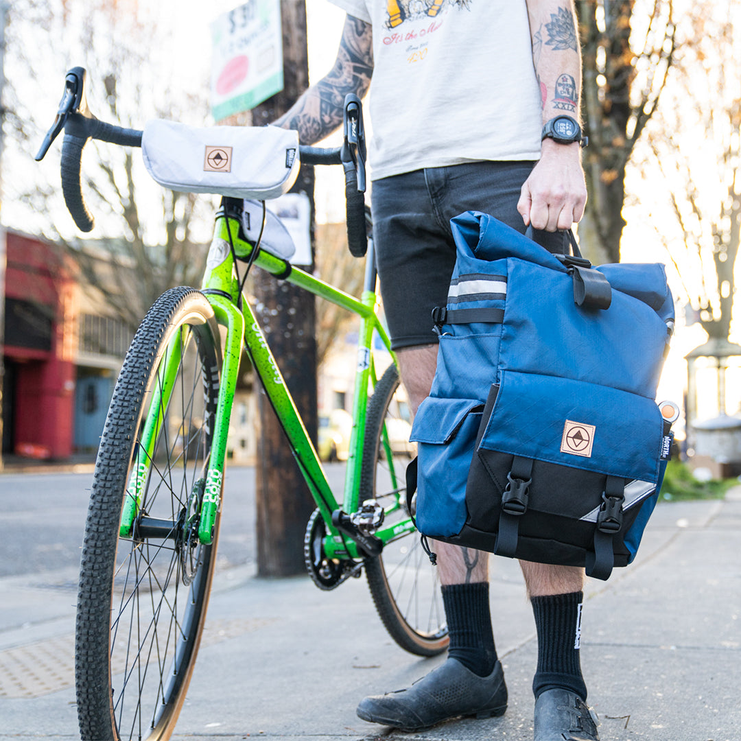 guy with bike holding a woodward backpack pannier