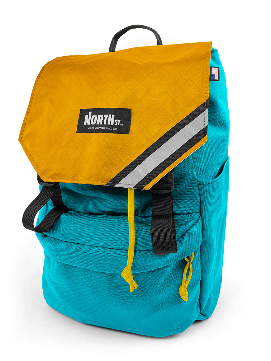 front view of belmont backpack in teal and gold