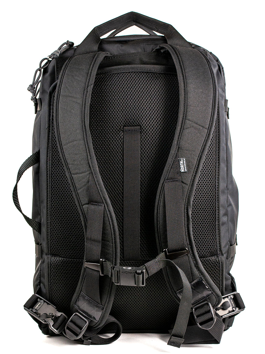 Back view of a black travel backpack showing backpack straps, premium buckle attachments and carry handles on a white background.