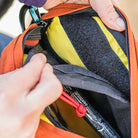 Detail shot showing a person installing hook and loop pocket into Piuoneer 9 Hip Pack | North St. Bags all-groups